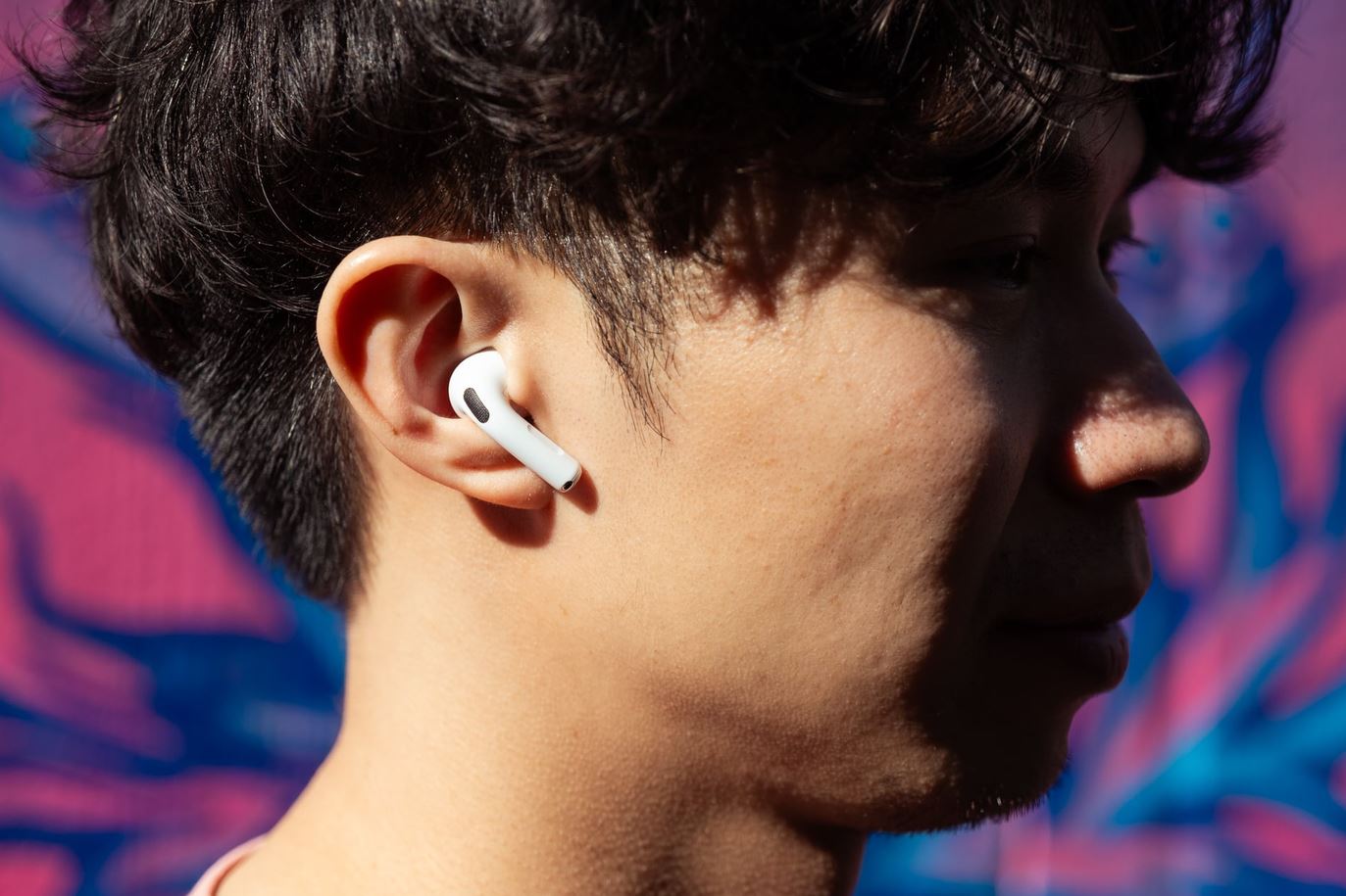 Человек слушает музыку в наушниках AirPods 5