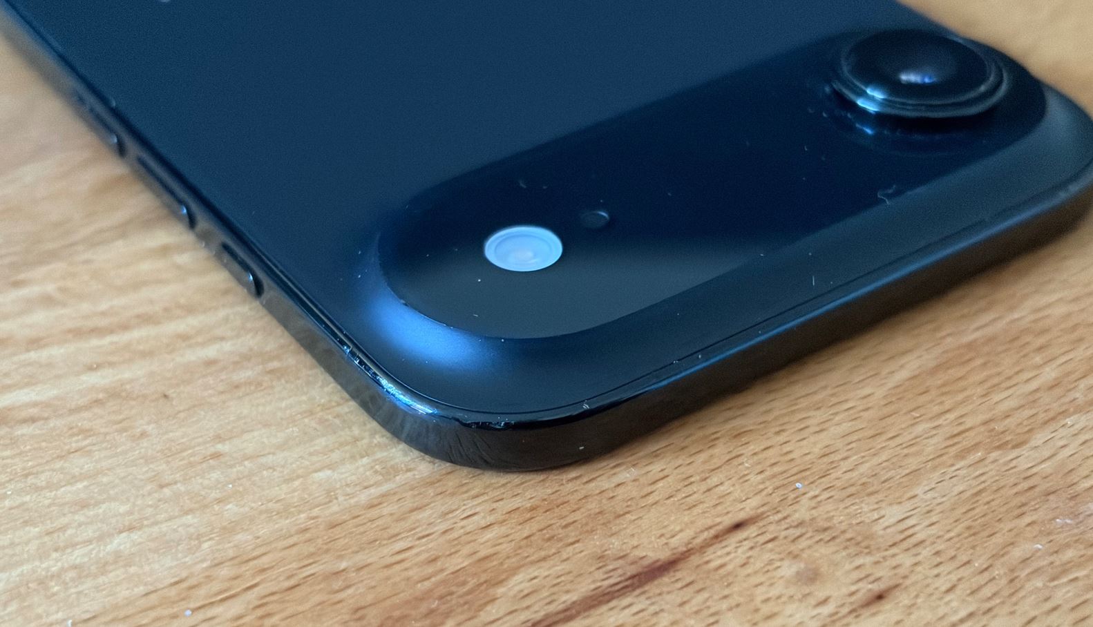 Небольшие следы на тёмной рамке iPhone крупным планом