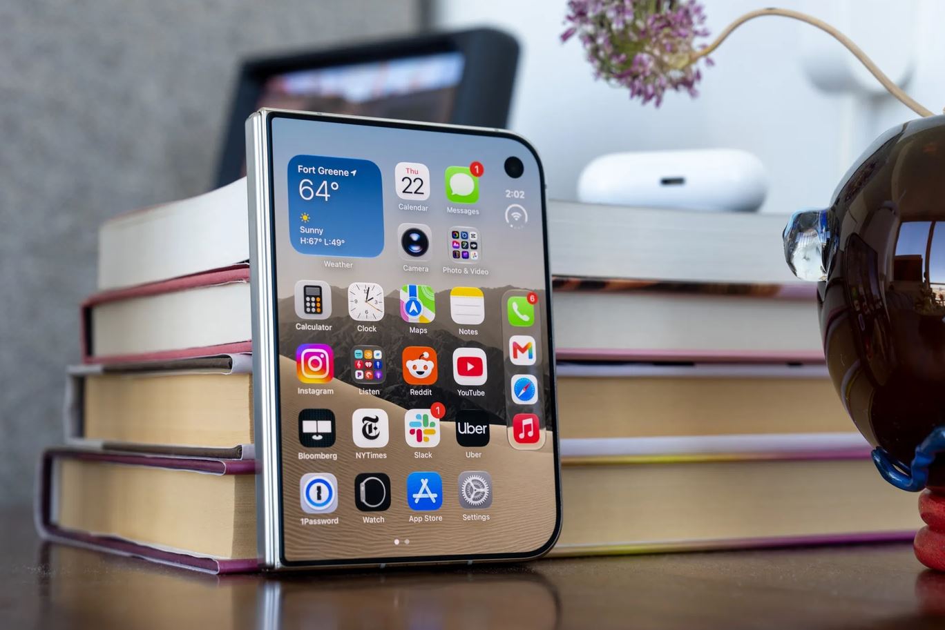 Сложенный iPhone Duo на стопке книг