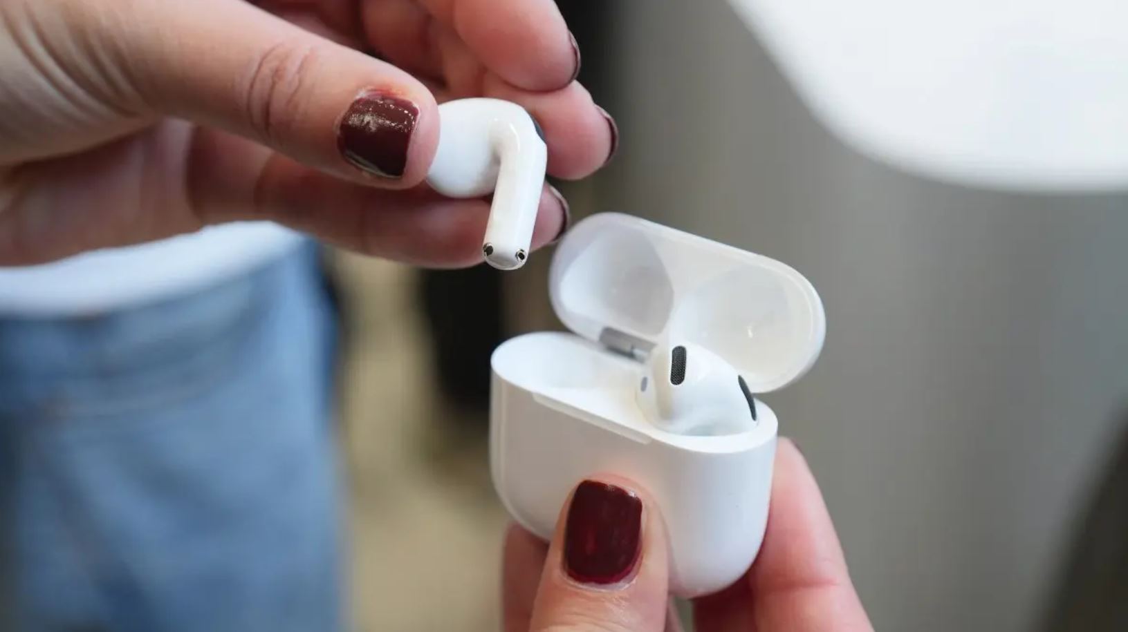 Наушник AirPods 5 над открытым зарядным кейсом