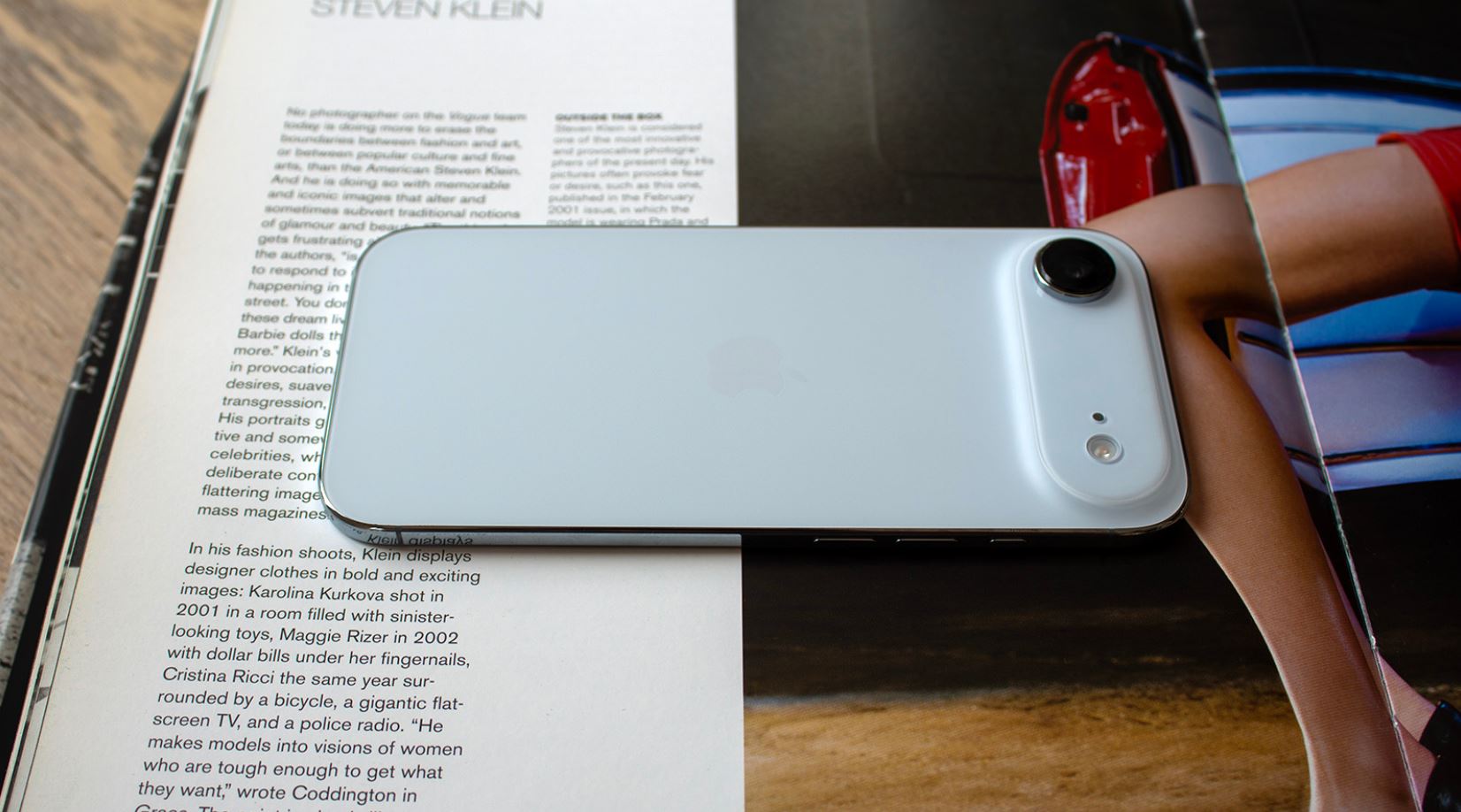 Голубой iPhone Air лежит на раскрытом журнале