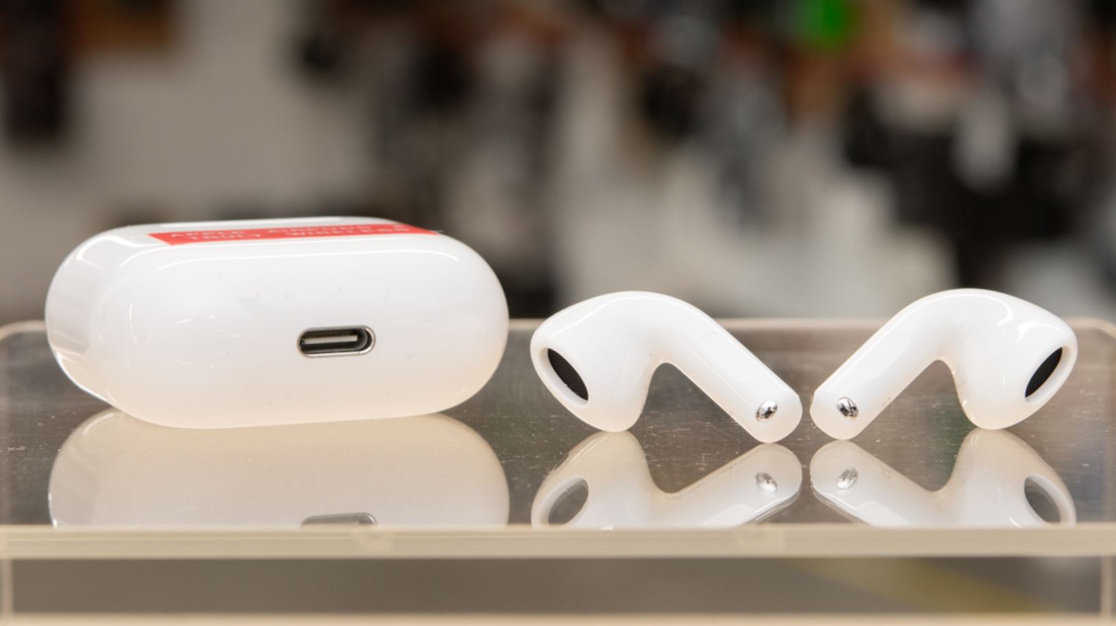 Наушники AirPods 4 рядом с зарядным кейсом