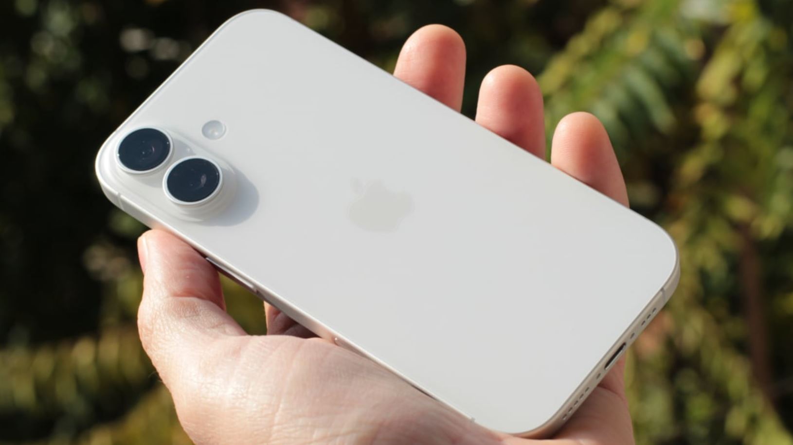 Белый iPhone 17 с двумя камерами в руке